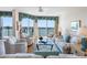 Inviting living room featuring plush seating, a glass coffee table, and a scenic water view from the balcony at 8040 Sailboat Key S Blvd # 402, St Pete Beach, FL 33707