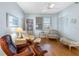Bright living room with hardwood floors, cozy chairs, and natural light at 8040 Sailboat Key S Blvd # 402, St Pete Beach, FL 33707