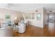 Open-concept living space with hardwood floors, comfortable seating, and a view of the kitchen and balcony at 8040 Sailboat Key S Blvd # 402, St Pete Beach, FL 33707