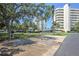 Well-maintained parking area with mature trees and convenient access to nearby buildings at 8040 Sailboat Key S Blvd # 402, St Pete Beach, FL 33707