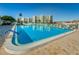 Inviting community pool with ample lounge chairs, and complex buildings in the background at 8040 Sailboat Key S Blvd # 402, St Pete Beach, FL 33707