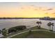 Scenic sunset view overlooking the water and a nearby park with palm trees and lush greenery at 8040 Sailboat Key S Blvd # 402, St Pete Beach, FL 33707