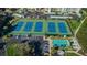 Aerial view showcasing the property's well-maintained tennis courts and shuffleboard amenities in a lush, landscaped setting at 8040 Sailboat Key S Blvd # 402, St Pete Beach, FL 33707