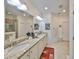 Bright bathroom featuring granite countertops with dual sinks and a large mirror at 807 Chipper Dr, Sun City Center, FL 33573