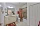 Bright bathroom featuring a granite-topped vanity, large mirror, and shower-tub combo with decorative curtain at 807 Chipper Dr, Sun City Center, FL 33573