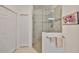 Bright bathroom featuring a glass enclosed shower, towel racks and tile flooring at 807 Chipper Dr, Sun City Center, FL 33573