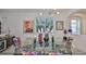 The dining room has a modern chandelier and glass table for elegant dining at 807 Chipper Dr, Sun City Center, FL 33573