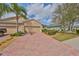 Inviting home exterior with a brick driveway, lush landscaping, and a convenient two-car garage at 807 Chipper Dr, Sun City Center, FL 33573
