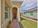 Inviting covered entryway featuring a brick walkway and a charming, dark wood front door at 807 Chipper Dr, Sun City Center, FL 33573