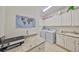 Well-organized laundry room with granite countertops, upper cabinets, washer, dryer, and a world map at 807 Chipper Dr, Sun City Center, FL 33573
