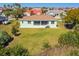 Aerial view of a home with a large backyard and lush green grass, surrounded by tropical vegetation at 834 Birdie Way, Apollo Beach, FL 33572