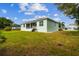 Spacious backyard features lush green grass and a private screened lanai for outdoor entertaining at 834 Birdie Way, Apollo Beach, FL 33572