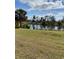 View of the backyard with a pond on a sunny day, enhancing the peaceful atmosphere of this lovely home at 834 Birdie Way, Apollo Beach, FL 33572