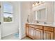 Well-lit bathroom featuring a wooden vanity with a white countertop and a window at 834 Birdie Way, Apollo Beach, FL 33572