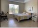 Cozy bedroom with a comfortable bed, a workspace desk, and ample natural light from the large window at 834 Birdie Way, Apollo Beach, FL 33572