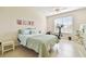 Bright bedroom featuring a queen-size bed, ceiling fan, and a workspace at 834 Birdie Way, Apollo Beach, FL 33572