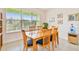 Bright dining room with a large window, wooden table and chairs, and tasteful wall decor at 834 Birdie Way, Apollo Beach, FL 33572