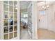 Inviting entryway showcasing glass paneled office doors, neutral tiling and natural light from the home's front door at 834 Birdie Way, Apollo Beach, FL 33572
