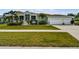 Charming single-Gathering home with a well-manicured lawn, two car garage, and screened front porch at 834 Birdie Way, Apollo Beach, FL 33572