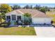 Beautiful one-story home with a three car garage, well-manicured lawn, and lush landscaping at 834 Birdie Way, Apollo Beach, FL 33572