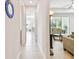 Hallway with light colored tiling leading to rooms bathed in natural light at 834 Birdie Way, Apollo Beach, FL 33572
