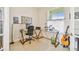 Dedicated home office with a glass-top desk, comfortable chair, and a window for natural lighting at 834 Birdie Way, Apollo Beach, FL 33572