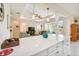 This kitchen has white quartz countertops, and a tray ceiling, seamlessly flowing into the living space at 834 Birdie Way, Apollo Beach, FL 33572