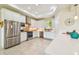 Bright kitchen boasts stainless steel appliances, white cabinetry, tile backsplash, and spacious countertops at 834 Birdie Way, Apollo Beach, FL 33572