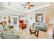 Spacious living room with an open layout, tile flooring, modern ceiling fan, and seamless flow to the kitchen at 834 Birdie Way, Apollo Beach, FL 33572