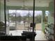 A large screened in patio with furniture and a grill, offering a view of the tranquil pond and serene setting at 834 Birdie Way, Apollo Beach, FL 33572