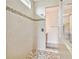 Modern tiled shower with mosaic accents and glass partition in this luxurious bathroom at 834 Birdie Way, Apollo Beach, FL 33572