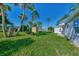 Lush backyard with a shed, palm trees, and vibrant greenery enhances the property's appeal at 8469 Aero Ave, North Port, FL 34287