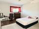 This bedroom features wood floors, a comfortable bed, and a window with bright light at 8711 Plum Ln, Temple Terrace, FL 33637