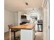 Open kitchen features butcher block island, stainless appliances, and white cabinetry at 8711 Plum Ln, Temple Terrace, FL 33637