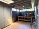 This is a screened-in patio featuring tile flooring, wooden support beams, and a work bench at 8711 Plum Ln, Temple Terrace, FL 33637
