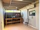 This is a screened-in patio featuring tile flooring, wooden support beams, and a work bench at 8711 Plum Ln, Temple Terrace, FL 33637