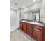 Bathroom with double sink vanity, granite countertop, and tiled shower at 10205 Cool Waterlily Ave, Riverview, FL 33578