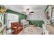 Beautiful Bedroom with green accent wall, white wainscoting, crib, glider and floral rug at 10205 Cool Waterlily Ave, Riverview, FL 33578