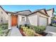 Inviting front exterior showcasing an orange front door, manicured landscaping, and a two-car garage at 10205 Cool Waterlily Ave, Riverview, FL 33578