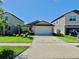 Charming single-Gathering home with a two-car garage, a well-manicured lawn, and lush landscaping at 10205 Cool Waterlily Ave, Riverview, FL 33578