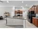 Open concept kitchen featuring a large island, granite counters, and dark wood cabinets at 10205 Cool Waterlily Ave, Riverview, FL 33578