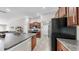 A modern kitchen with an island, wood cabinets, granite counters and stainless-steel appliances at 10205 Cool Waterlily Ave, Riverview, FL 33578