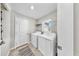 Bright laundry room with a side-by-side washer and dryer, window, and neutral walls at 10205 Cool Waterlily Ave, Riverview, FL 33578