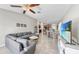 Open-concept living room with tile floors, a ceiling fan, and access to the kitchen and dining area at 10205 Cool Waterlily Ave, Riverview, FL 33578