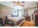 Cozy bedroom featuring hardwood floors, a ceiling fan, and a dresser with a mirror at 10352 Lansfield St, Spring Hill, FL 34608