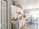 Well-lit kitchen showcasing white cabinets, modern appliances, and a dining area near the window at 10352 Lansfield St, Spring Hill, FL 34608