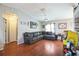Comfortable living room featuring hardwood floors, a generous leather couch, and a ceiling fan at 10352 Lansfield St, Spring Hill, FL 34608