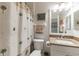 Bright bathroom with a white vanity, granite countertop, and decorative palm tree shower curtain at 129 Treviso Ct, North Venice, FL 34275