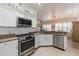 Well-lit kitchen featuring white cabinets, stainless steel appliances, and tiled backsplash for a modern look at 129 Treviso Ct, North Venice, FL 34275