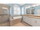 Modern bathroom features double sinks, a soaking tub, a tiled shower, and great natural light at 129 Treviso Ct, North Venice, FL 34275